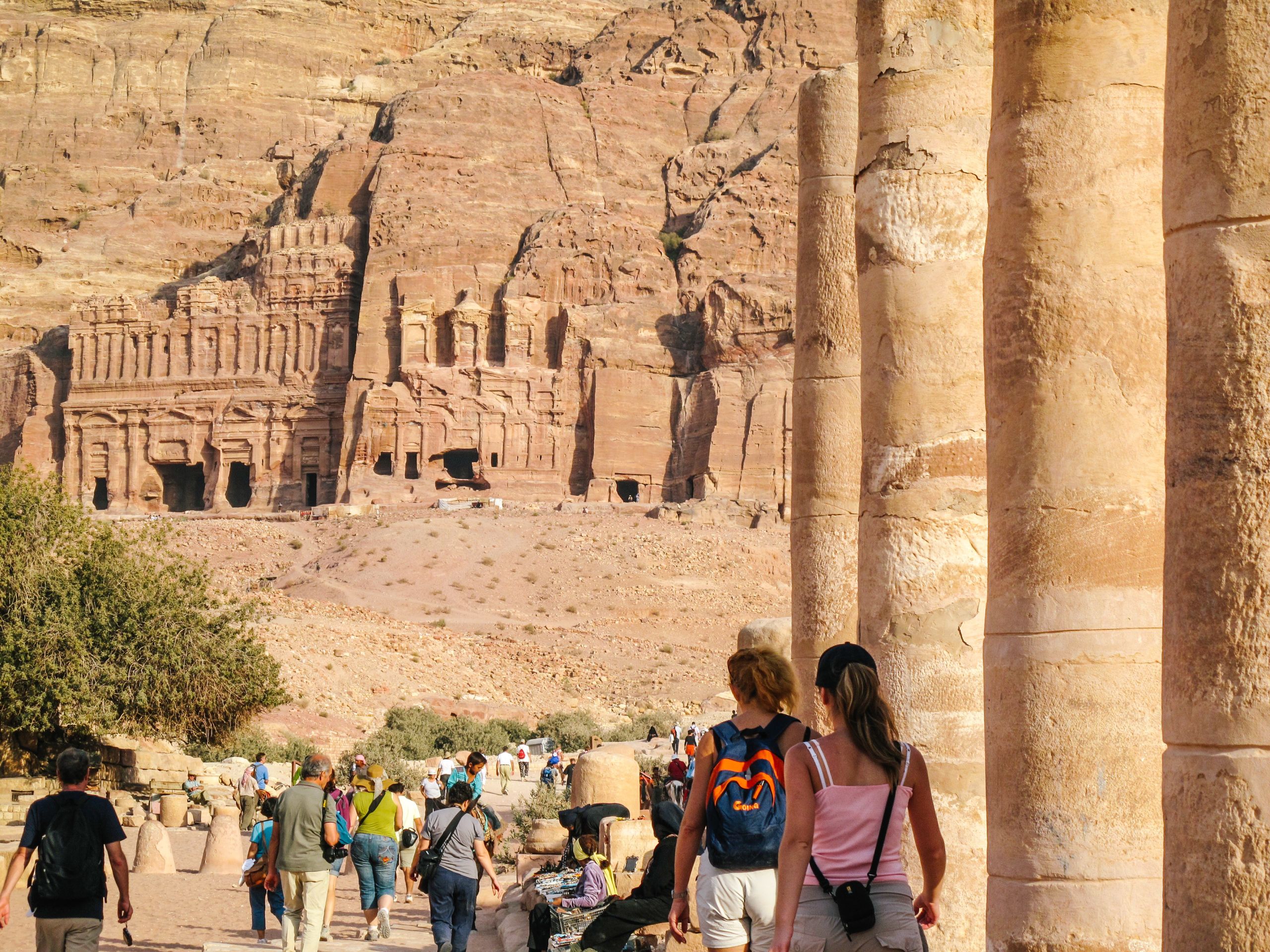 Visitatori esplorano le tombe scolpite nella roccia a Petra, Giordania